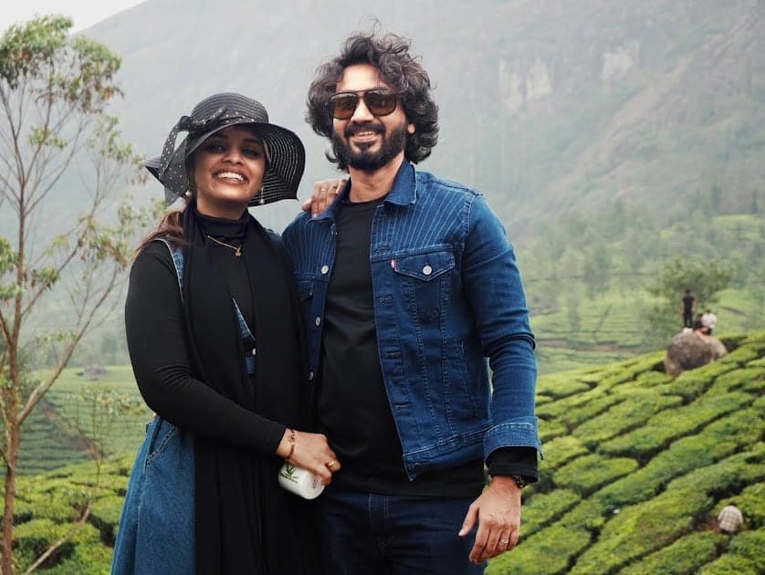 Fazna in a wide hat and Nisham in a denim jacket among tea bushes